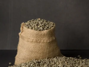 Gorkha Green Coffee Beans spread on a white surface, showcasing their premium quality