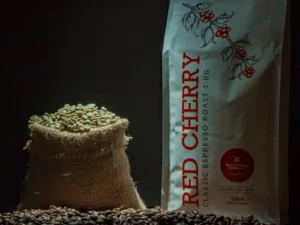 Commercial PLB Green Beans from Red Cherry Coffee in eco-friendly jute packaging beside a roasted beans pack.